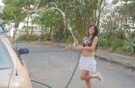 La esbelta latina Denisse Gómez presume de tetas postizas en un túnel de lavado al aire libre