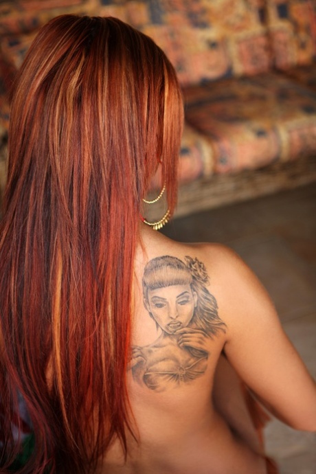 Inked redheaded babe Ashley Bulgari spreads her hot twat while posing naked