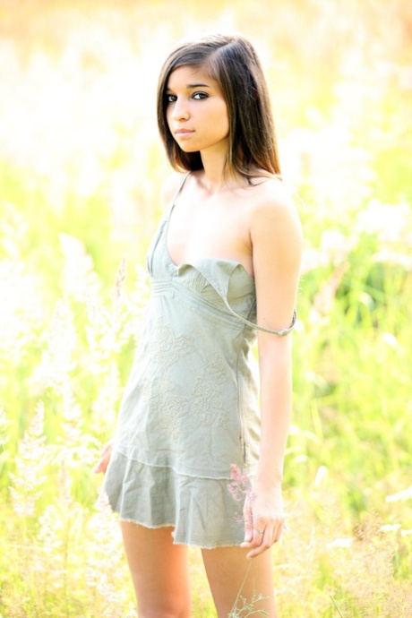 Den slanke tenåringsmodellen Nika tar av seg kjolen og poserer naken i naturen.