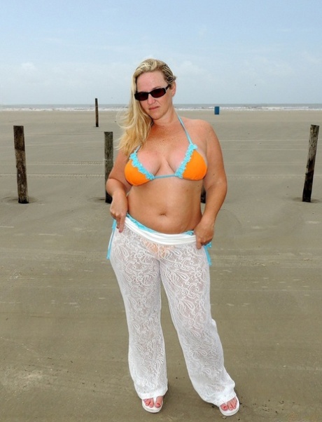 A MILF Dee Siren, de baixa estatura, despe-se na praia e expõe as suas curvas monstruosas
