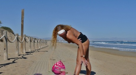 Ondeugende Spaanse MILF Natalie K pissen terwijl ze naakt op het strand speelt