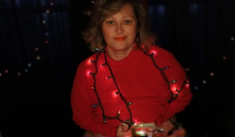 MILF amateur gordita posa en su traje sexy bajo las luces de Navidad