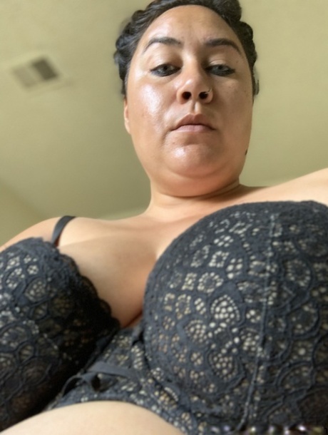 Angry mature woman poses in her bra and shows her sexy cleavage