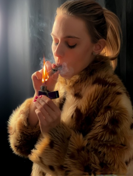 Une blonde avec une queue de cheval pose dans son manteau de fourrure en fumant une cigarette.
