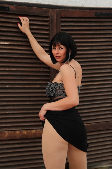 Mature dark-haired Desyra Noir shows her big tits & poses in pantyhose