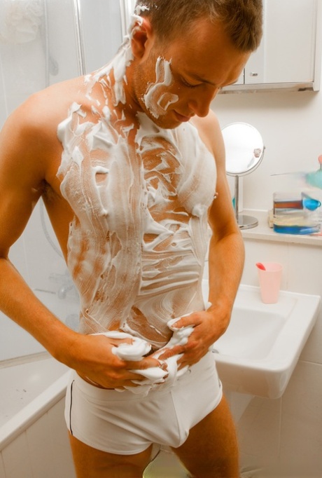 Adorable inked gay shows his sweet ass and puts shaving foam on his body