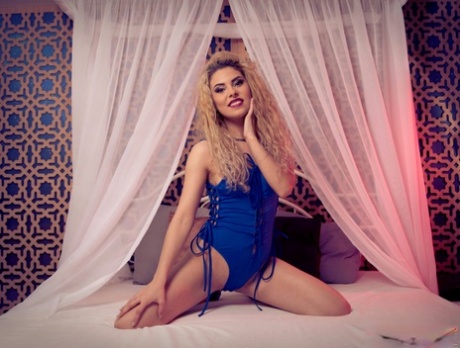 La blonde Aisha Devereaux pose de manière provocante dans sa lingerie bleue et ses talons.