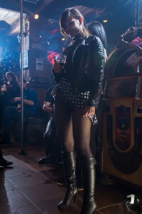ブーツを履いたセックスポット、ジェニー・スミスが公衆の面前でパンストを穿いて刺激的なアップスカートを見せる。