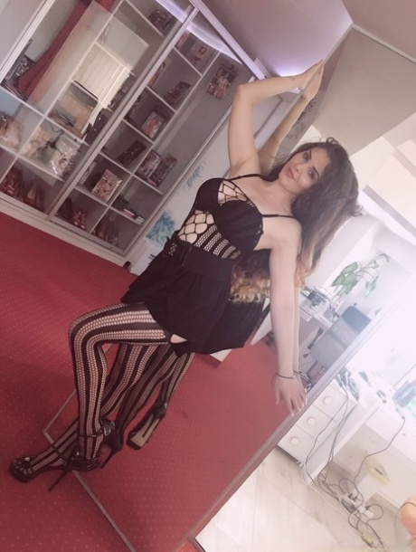 La jeune femme brune Alessia Rosse fait un tease chaud en portant des bas et des talons hauts.