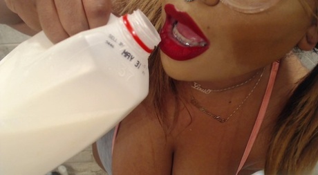 MILF blonde à lunettes Black DD Mamba versant du lait sur ses gros seins