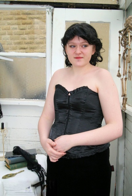 Dark-haired MILF posing in her black corset and skirt in a solo