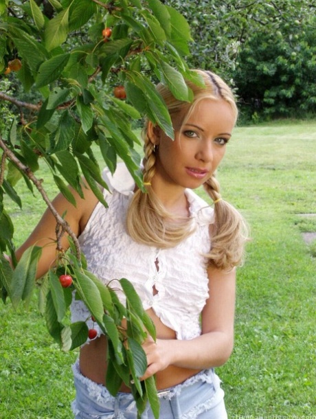 La jeune blonde Jennifer Reed grimpe à un arbre et joue avec un godemiché sur sa chatte bien taillée.