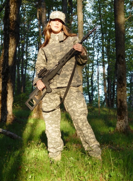 Lieve militaire babe toont haar enorme meloenen en poseert in het bos