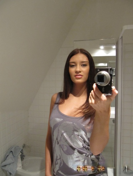Verführerisches Babe stellt ihre großen Titten zur Schau, während sie nackte Selfies im Badezimmer macht