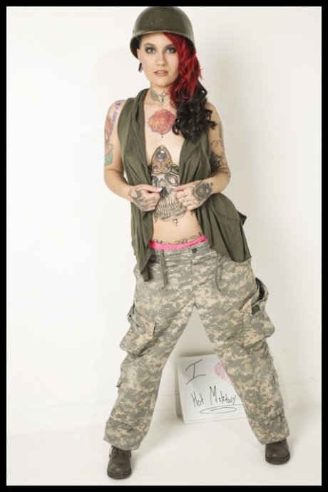 Ragazza militare sexy che mostra i suoi fantastici tatuaggi e il suo grande culo