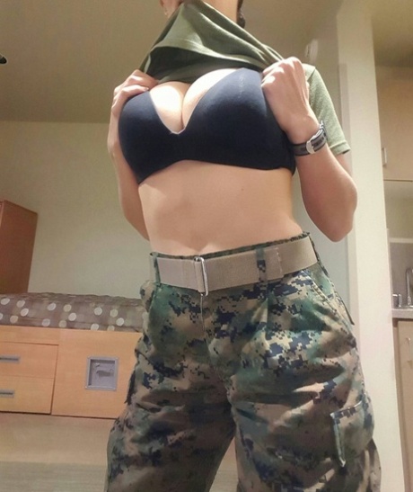 Sexy babe med store juggs tar av seg militæruniformen og poserer i en solo.
