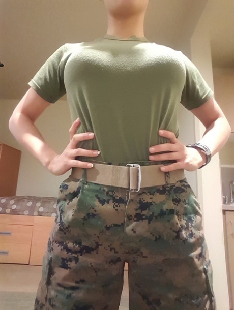 Heißes Babe mit großen Tüten zieht ihre Militäruniform aus und posiert in einem Solo