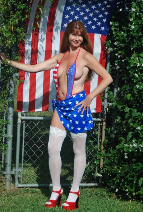 MILF excitada num biquíni com a bandeira americana exibe as suas incríveis mamas ao ar livre