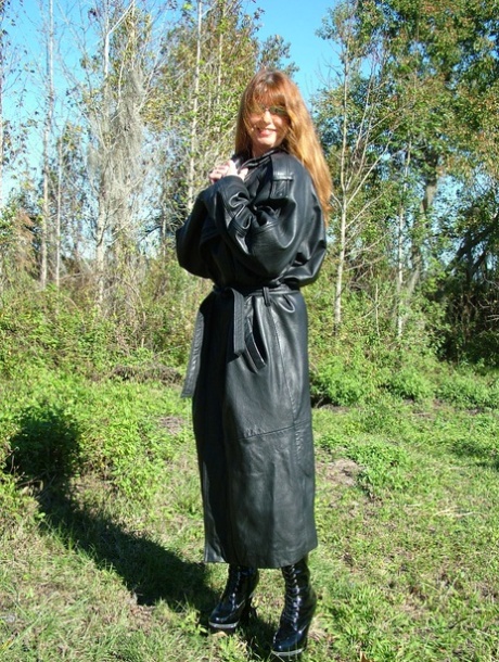 Horny MILF shows off her huge juggs and poses in black leather boots outdoors