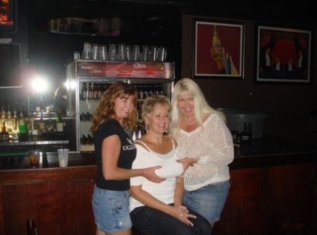 Horny MILF with a shaved cunt Mandi Sins shows her ass and tits in a bar