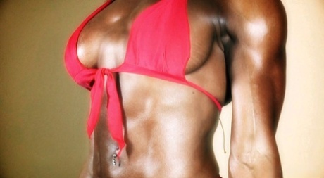 Alexis Ellis, bodybuilder à la poitrine généreuse, exhibe ses gros muscles dans un bikini rouge moulant.