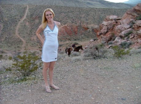 Blonde teen Justina Gold flashes her panties while posing in the mountains