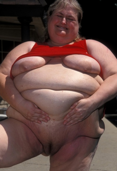 Madalyn McGrath, mulher madura e gorda, exibe as suas mamas descaídas e a sua rata careca à beira da piscina