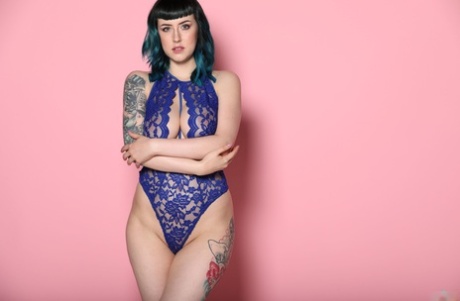 A modelo com tatuagens Lisha Blackhurst mostra as suas mamas enquanto posa com um body