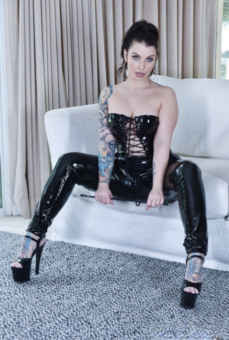 Donker haired babe in een latex kleren Ivy Lebelle rijdt een lul na strippen