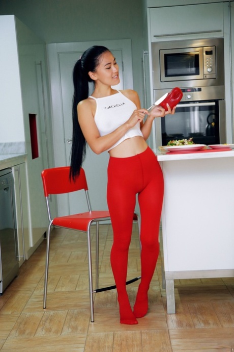 Kimiko, une jeune asiatique sexy, se déshabille après avoir coupé des légumes dans la cuisine.