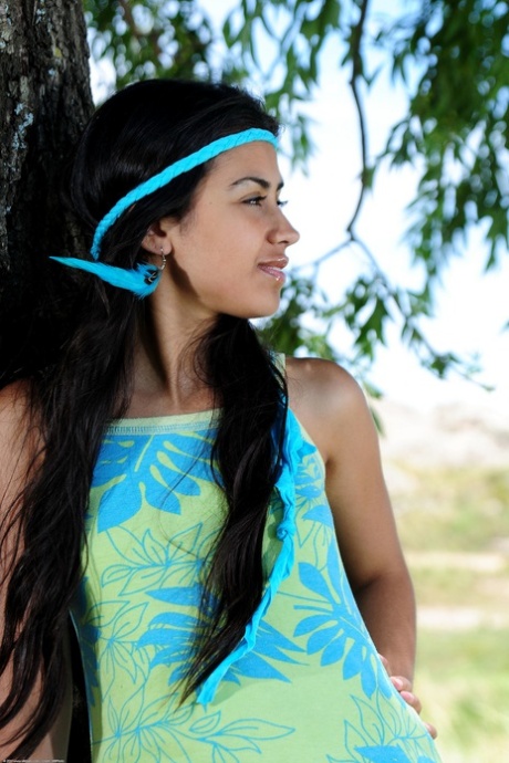 Exotiska Latina Ambar klär av sig under det stora trädet och rör vid sin håriga fitta