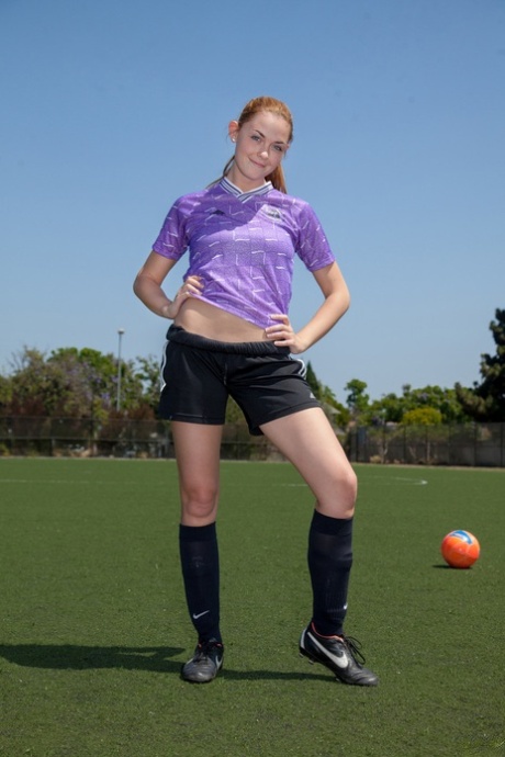 Sportliche rothaarige Teenagerin Bailey Rayne zeigt ihren engen Arsch auf dem Fußballfeld