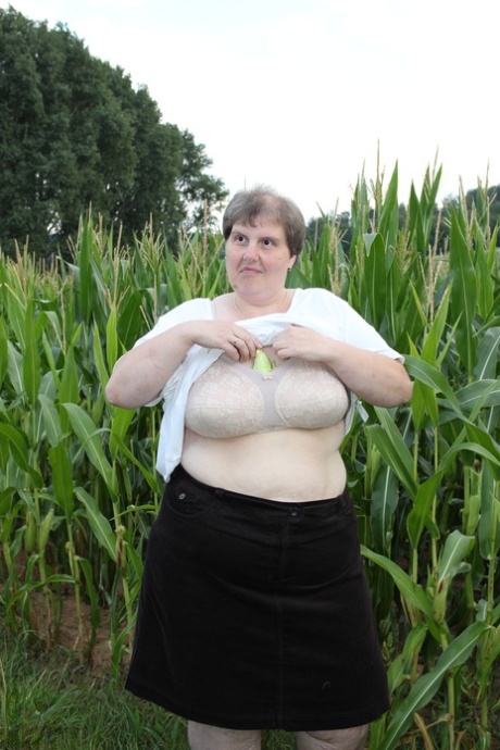 La rellenita europea Tina C se desnuda en un campo de maíz y masturba su coño maduro