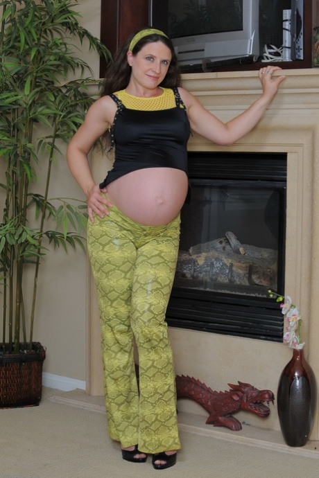 怀孕的业余少女安吉拉在壁炉边用手指抚摸多毛的阴部和屁股