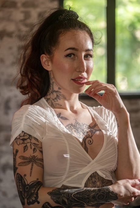 Esluna Love, uma puta com tatuagens, exibe as suas mamas falsas e a sua cona aparada num solo