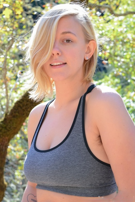 La blonde amatrice Emerald Lee se déshabille en plein air et masse sa chatte poilue.
