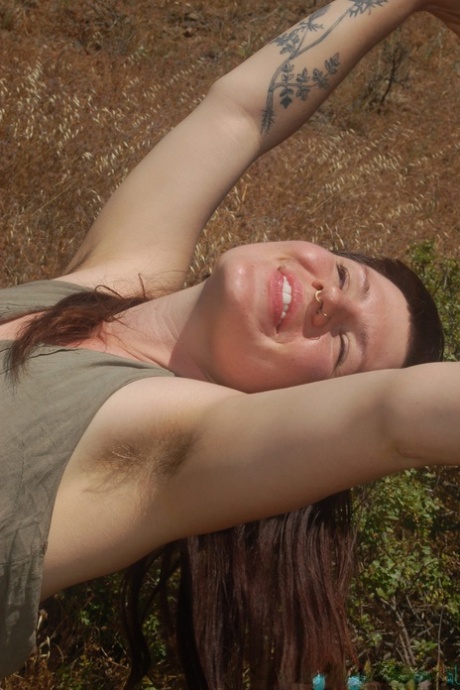 Den høye jenta Olivia Rose stripper i naturen og viser sin hårete vagina på nært hold