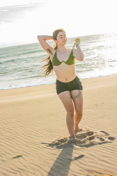 Schoonheid Kisa Fae strips haar groene bikini op het strand & shows haar harige lichaam
