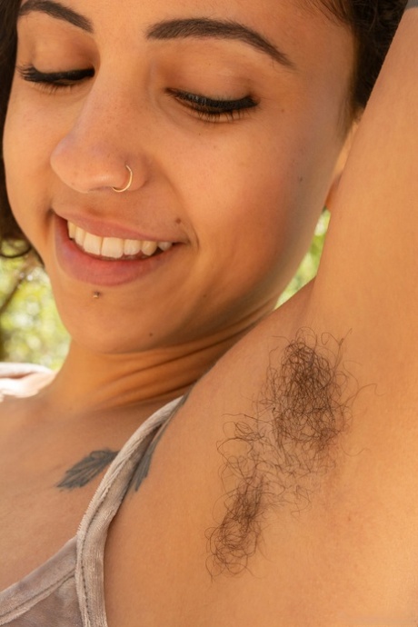 Cute ebony Frankie undresses and reveals her hairy tattooed body in nature
