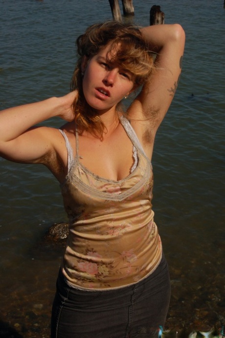 淫荡的年轻荡妇莉拉在水边脱衣，露出毛茸茸的身体