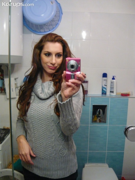 Vica, une adolescente rousse, se déshabille et prend des selfies de ses gros seins dans le miroir.