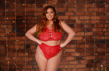 Le mannequin joufflu Lucy Vixen pose dans sa lingerie rouge et dévoile ses gros seins.