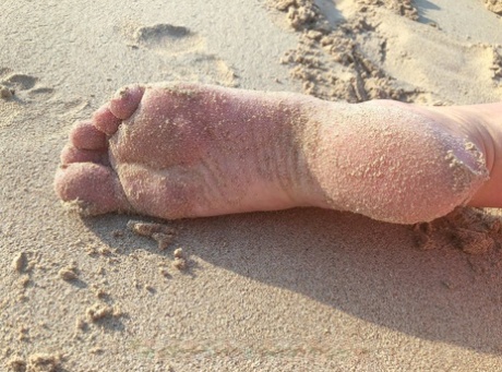 MILF excêntrica com pernas longas Lara posa na praia e provoca com os seus pés