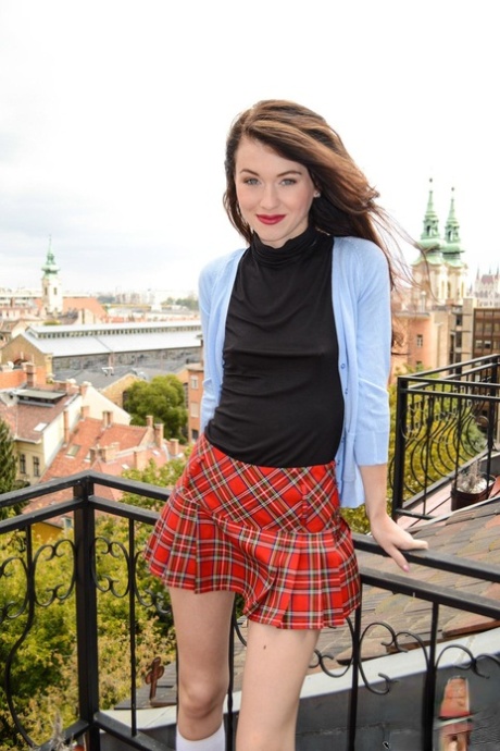 Den europeiska skolflickan Mischa Cross klär av sig och visar sina hål på en fotosession