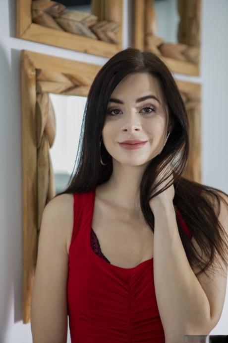 Подростковая порнозвезда Дженни Долл снимает красное платье и показывает свою попку в чулках