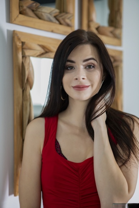 La star du porno Jenny Doll enlève sa robe rouge et montre sa chatte en bas.