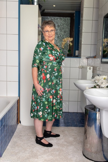 Ondeugende oma Petra toont haar kutje in een kinky striptease in de badkamer