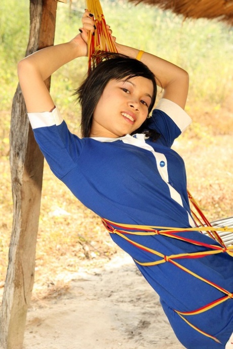 Den sexy asiatiske jenta Kung tar av seg klærne for å vise frem den innbydende, oppsvulmede fitta.