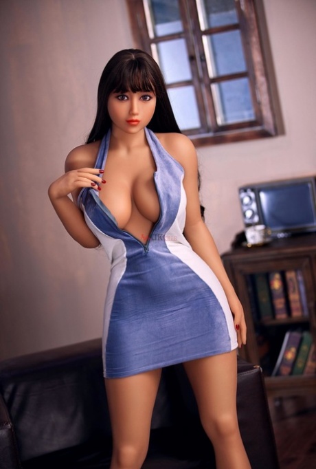 La poupée sexuelle Saya enlève sa robe chaude et se frotte les seins.