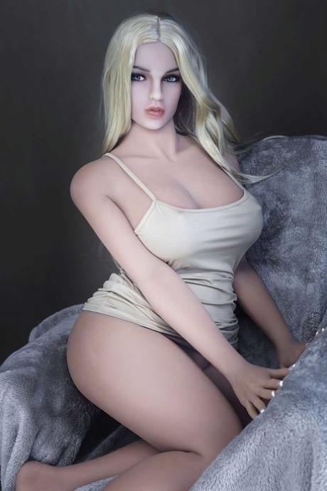 Une magnifique poupée sexuelle blonde montre ses gros seins et son superbe cul